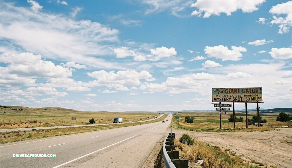 Open highway with roadside attraction sign in the distance under a wide sky